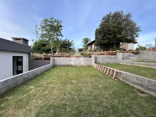 Vista de um jardim gramado cercado por muros de pedra