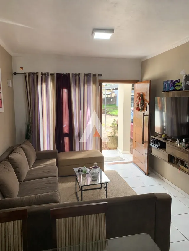 Sala de estar com sofá e cortinas em um imóvel no Brasil.