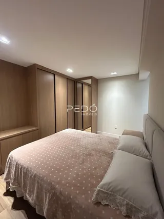Quarto com cama e painéis de madeira em um imóvel.