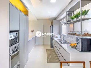 Cozinha moderna com armários brancos e bancada clara.