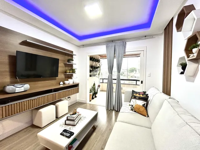 Sala de estar moderna com sofá e painel de TV em um apartamento.