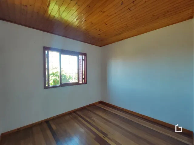 Quarto com piso de madeira e teto inclinado.