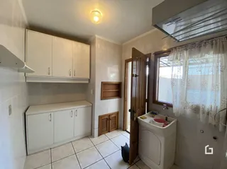Hall com armários brancos e portas de madeira na residência.
