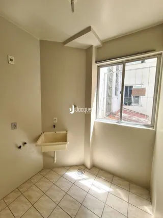 Interior de um corredor com piso de cerâmica e janela.