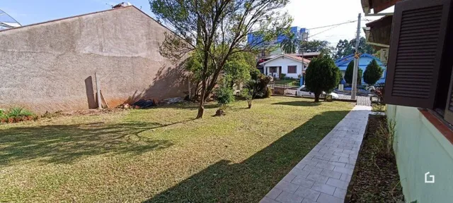 Vista externa de um jardim gramado com uma parede de fundo.