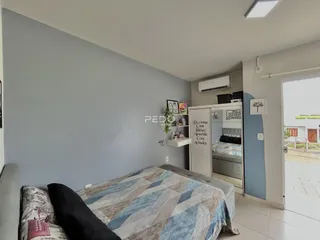 Quarto com cama e armário branco.