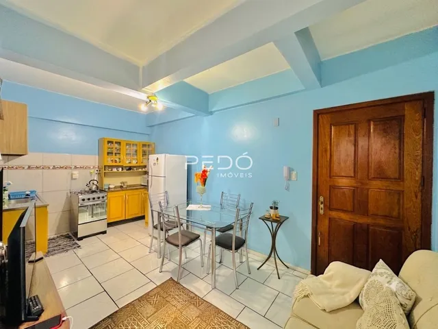 Sala de estar com paredes azul claro e porta de madeira em uma residência em Lajeado, Brasil.