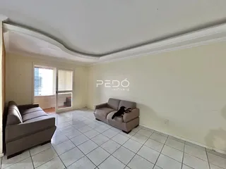 Sala de estar com sofá e piso de cerâmica clara.
