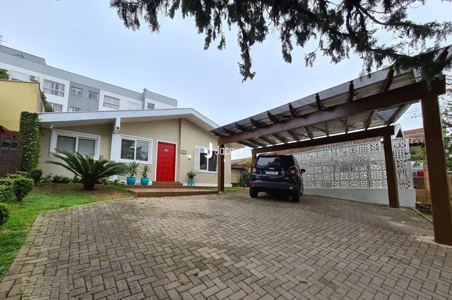Fachada de uma residência com estrutura de madeira na frente.