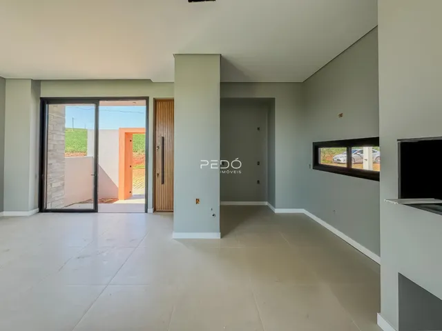 Vista interna de uma sala de estar com porta de vidro abrindo para o exterior.