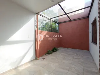 Vista de uma área externa pavimentada com piso de cerâmica.