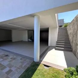 Vista de uma área externa com piso de concreto e uma coluna branca.