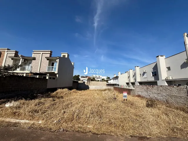 Fachada de casas residenciais em Lajeado, Brasil, com grama seca no primeiro plano.