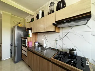 Vista da cozinha moderna com armários de madeira e bancada escura.