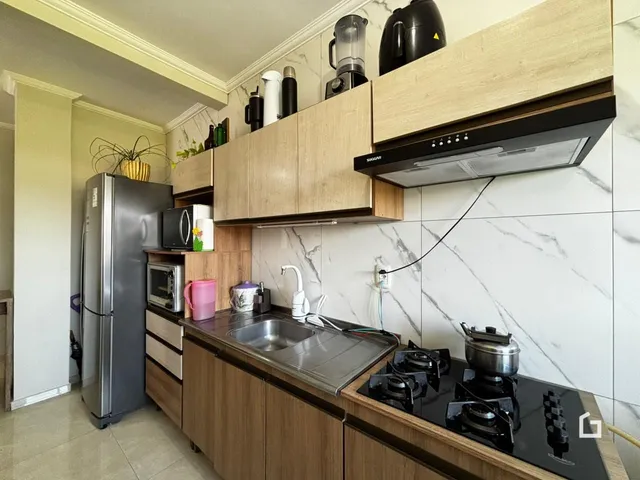 Vista da cozinha moderna com armários de madeira e bancada escura.