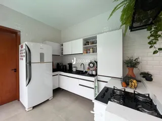 Foto de uma cozinha com armários brancos e revestimento de azulejos brancos.