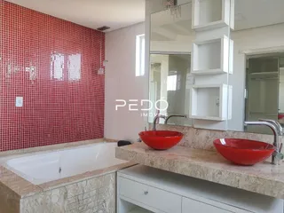 Foto de um banheiro com revestimento de cerâmica vermelha e bancada.