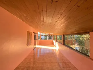 Vista de um corredor interno com paredes alaranjadas e teto de madeira.