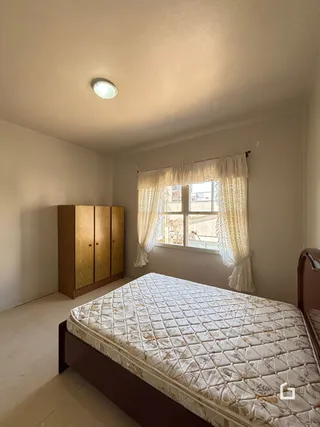 Quarto com cama e armário de madeira em um imóvel no Brasil.