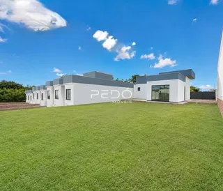 Fachada de uma casa moderna branca em Lajeado, Brasil, com gramado verde.