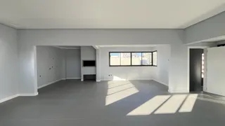 Sala ampla com piso cinza e grande janela.