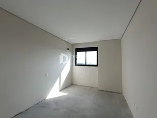 Interior de um cômodo com paredes brancas e piso de concreto.