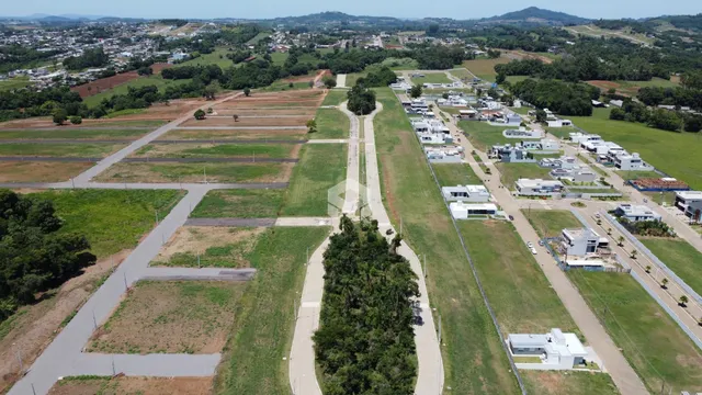 Vista aérea de um loteamento em Lajeado, Brasil, mostrando áreas verdes e estradas.