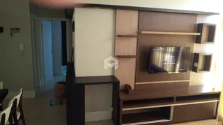 A sala de estar exibe uma parede com nichos e uma televisão montada.