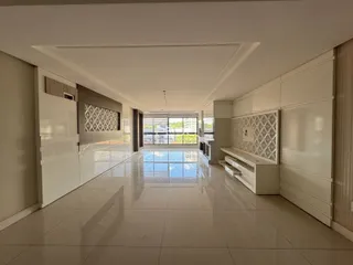 Sala de estar ampla e clara com acabamentos brancos.