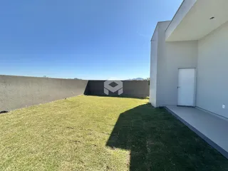 Vista da fachada de uma residência com um grande gramado no quintal.