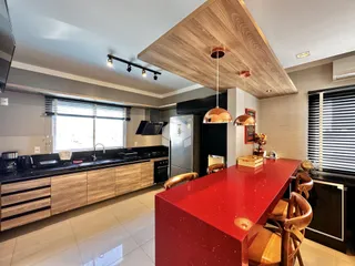 Uma cozinha moderna com ilha vermelha e armários de madeira.
