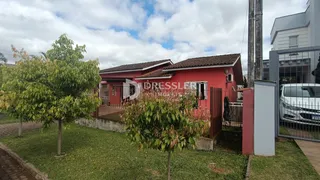 Fachada de uma residência vermelha em Lajeado, Brasil, com jardim frontal.