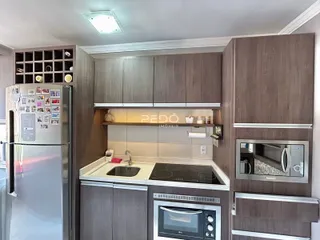 Vista da cozinha moderna com armários e eletrodomésticos em Lajeado.