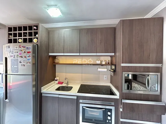 Vista da cozinha moderna com armários e eletrodomésticos em Lajeado.