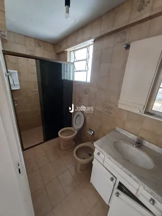 Foto de um banheiro com piso de cerâmica e bancada branca.