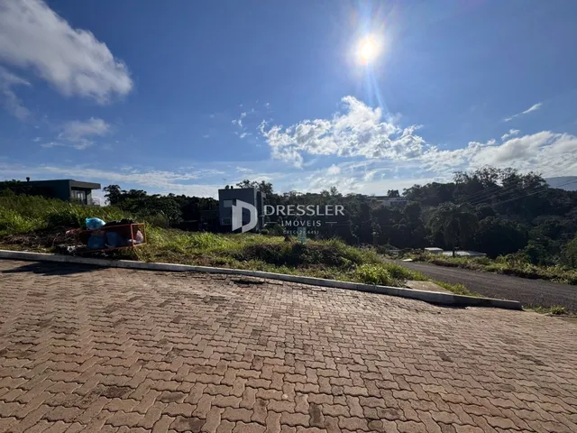 Vista externa da propriedade com paisagem e área pavimentada.