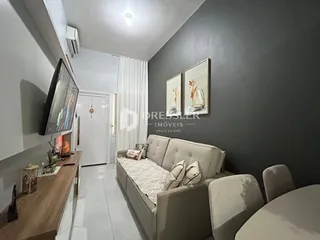 Sala de estar com sofá e televisão em um imóvel no Brasil.