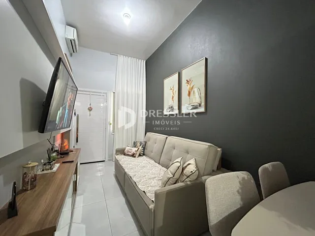 Sala de estar com sofá e televisão em um imóvel no Brasil.