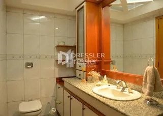 Foto de um banheiro interno com revestimento de cerâmica branca.