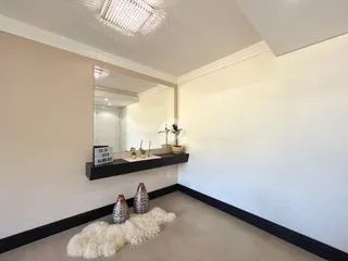 Ambiente interno com parede clara e espelho decorativo.