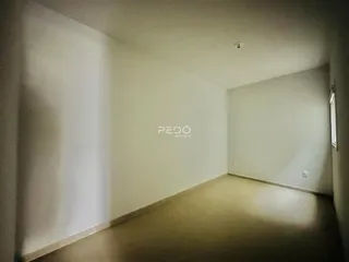 Vista interna de um corredor com paredes brancas.