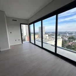 Vista panorâmica da cidade através de grandes janelas de uma sala.