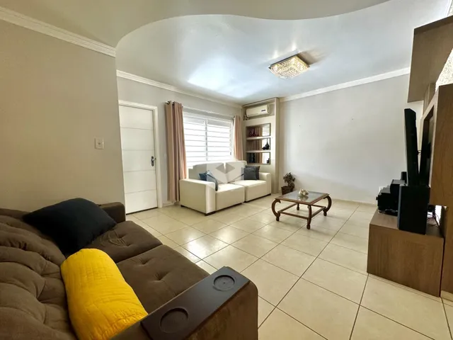 Sala de estar com sofá e piso de cerâmica em um imóvel no Brasil.