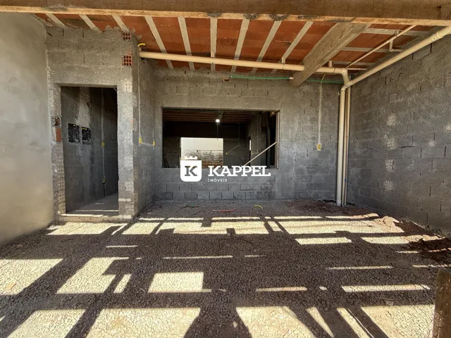 Foto de um espaço interno em construção com paredes de concreto aparente.