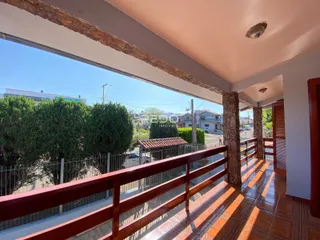 Vista da área externa com vegetação e cerca de madeira.