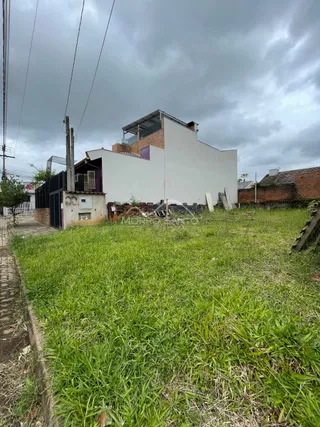 Fachada de uma residência em Lajeado, Brasil, com gramado alto na frente.