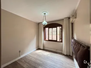 Esta é uma foto do interior de uma sala com piso de madeira clara e janela grande.
