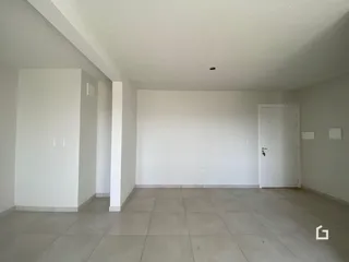 Uma foto de um cômodo interno com paredes brancas e piso de cerâmica.
