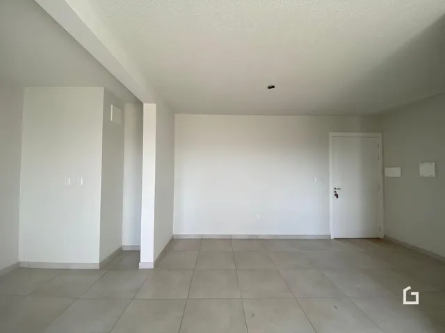 Uma foto de um cômodo interno com paredes brancas e piso de cerâmica.