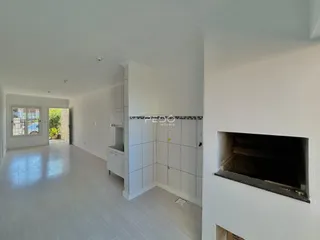 Hall de entrada com piso claro e paredes brancas.